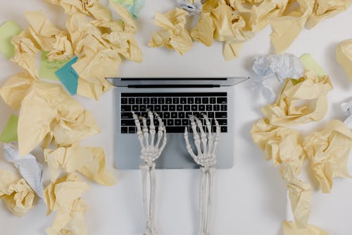 Free Crumpled Papers Beside a Laptop Stock Photo