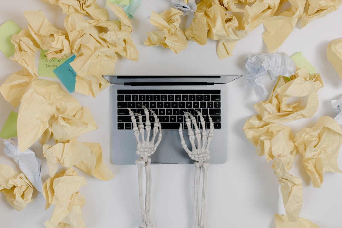 Free Crumpled Papers Beside a Laptop Stock Photo