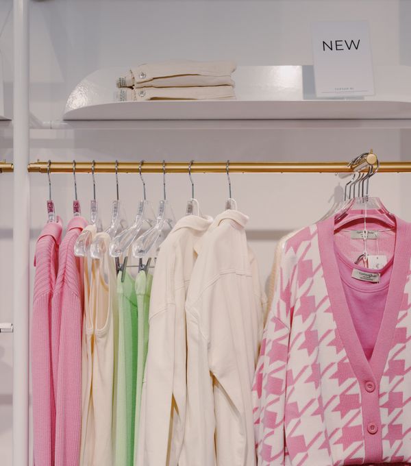 Ladies cardigan and dress hanging on a boutique clothing rack