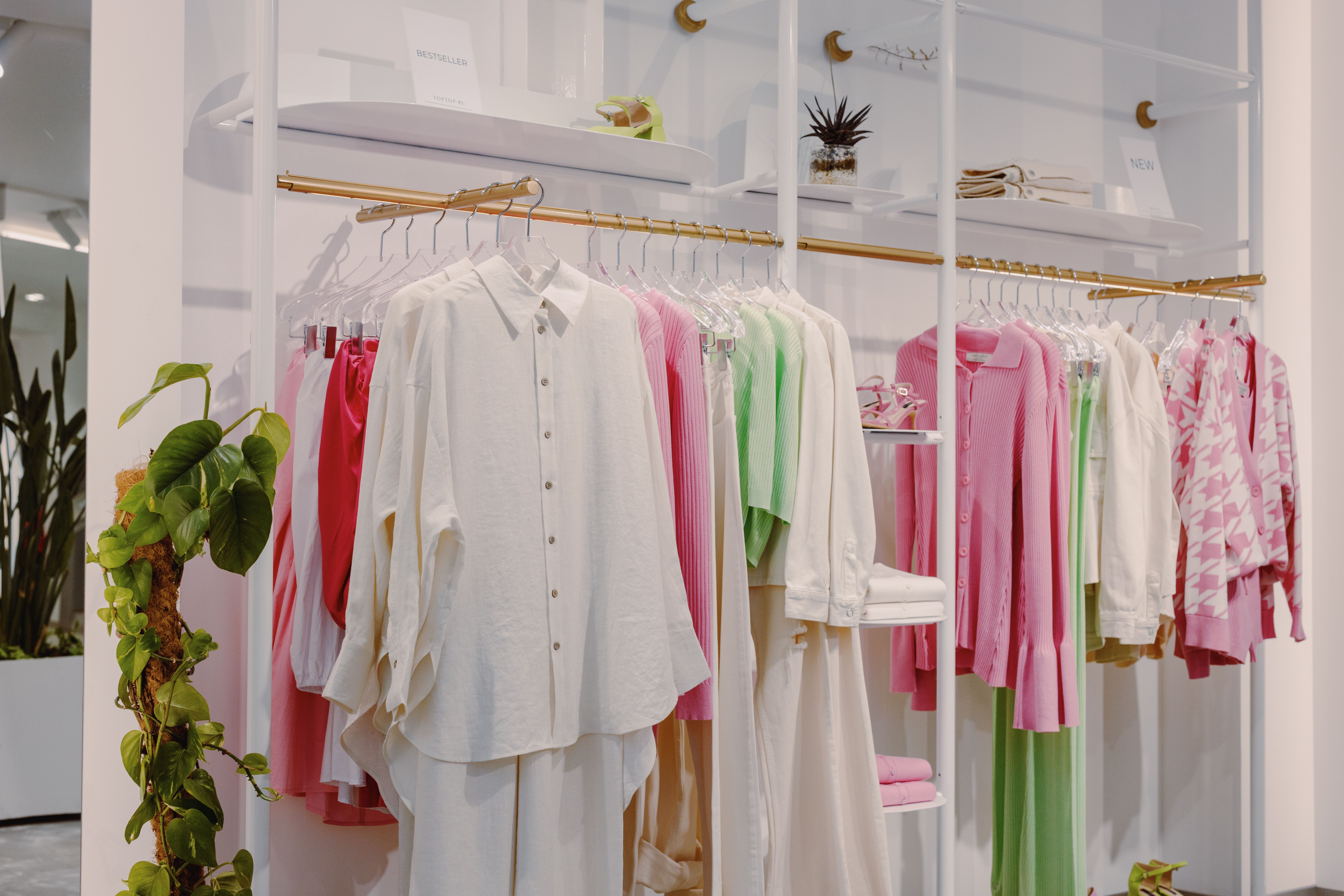 Finished garment samples hanging on a clothing rack in a fashion studio