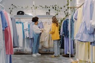 Woman in White Long Sleeve Shirt and Gray Pants Standing Beside Woman in Yellow Long Sleeve