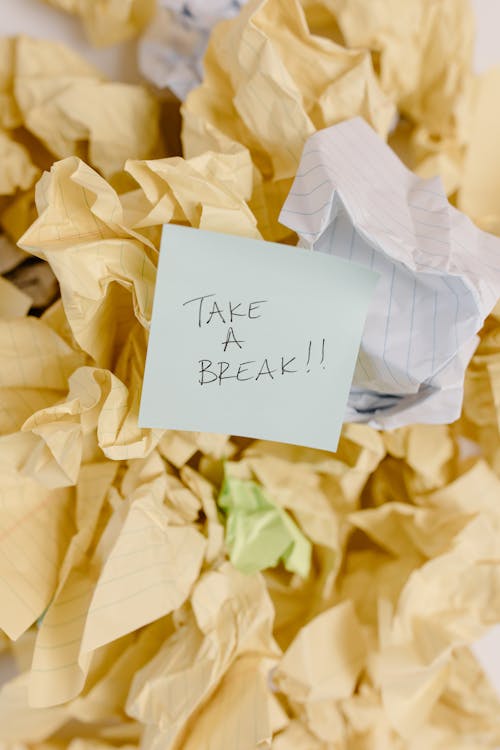 A Note Saying "Take a Break" Lying on a Pile of Scrunched Pieces of Paper 