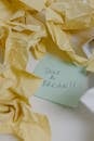 TextA Sticky Note around Crumpled Yellow Papers