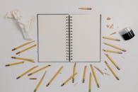 A Flatlay of a Notebook Surrounded by Broken Pencils