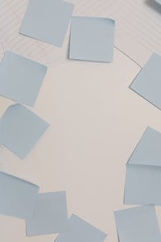 Overhead view of blue sticky notes arranged in a circle on lined paper, ideal for copy space.