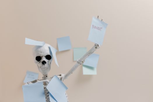 Humorous depiction of burnout with a skeleton holding sticky notes, representing overwork.