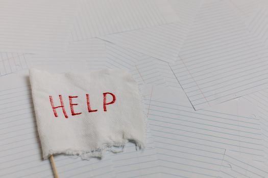 A flag with 'HELP' text on a lined paper background signifying distress or need for assistance.