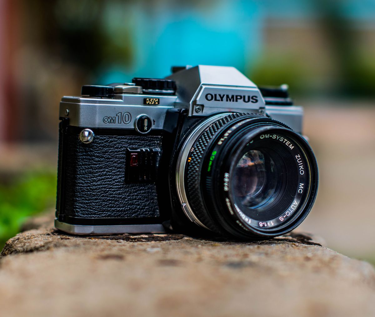 Close-up of a classic Olympus OM10 film camera with a lens, showcasing vintage photographic equipment.