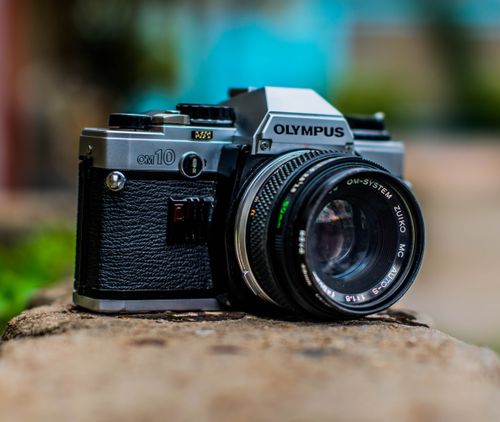 Free Close-up of a classic Olympus OM10 film camera with a lens, showcasing vintage photographic equipment. Stock Photo