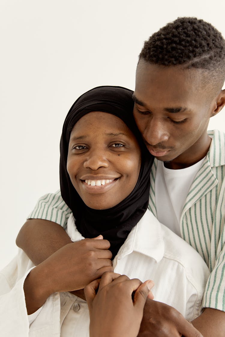 Man In Striped Polo Hugging Woman In Hijab 