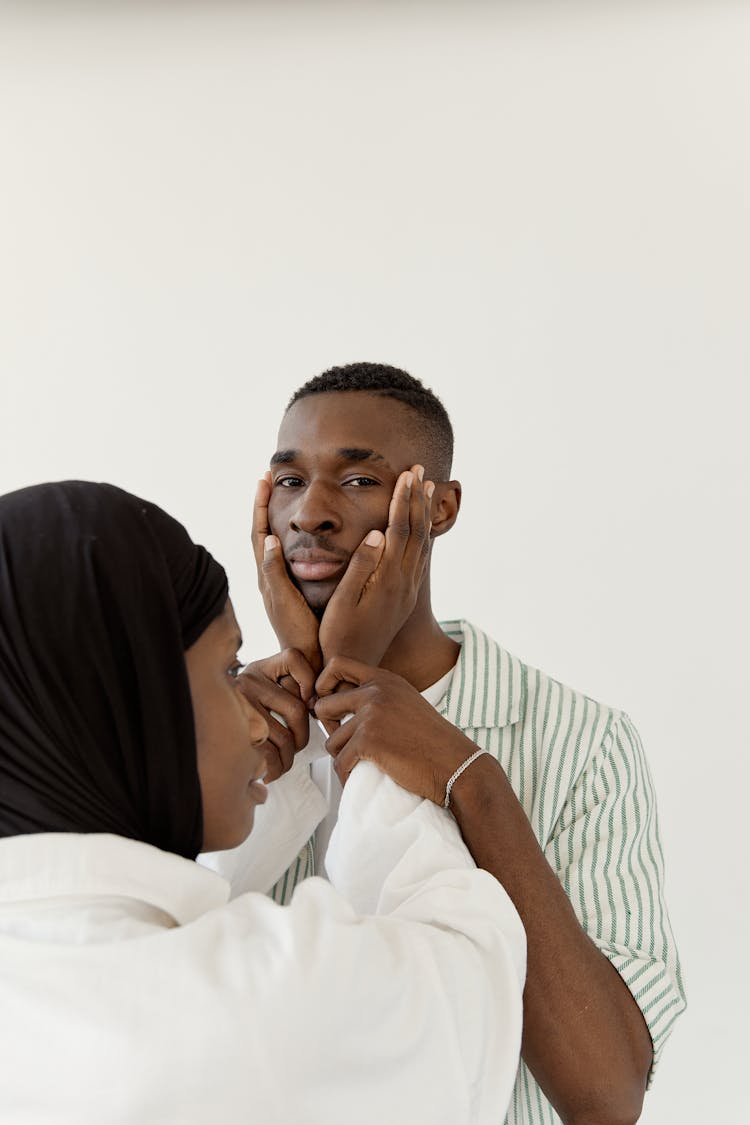 A Woman Holding A Man's Face