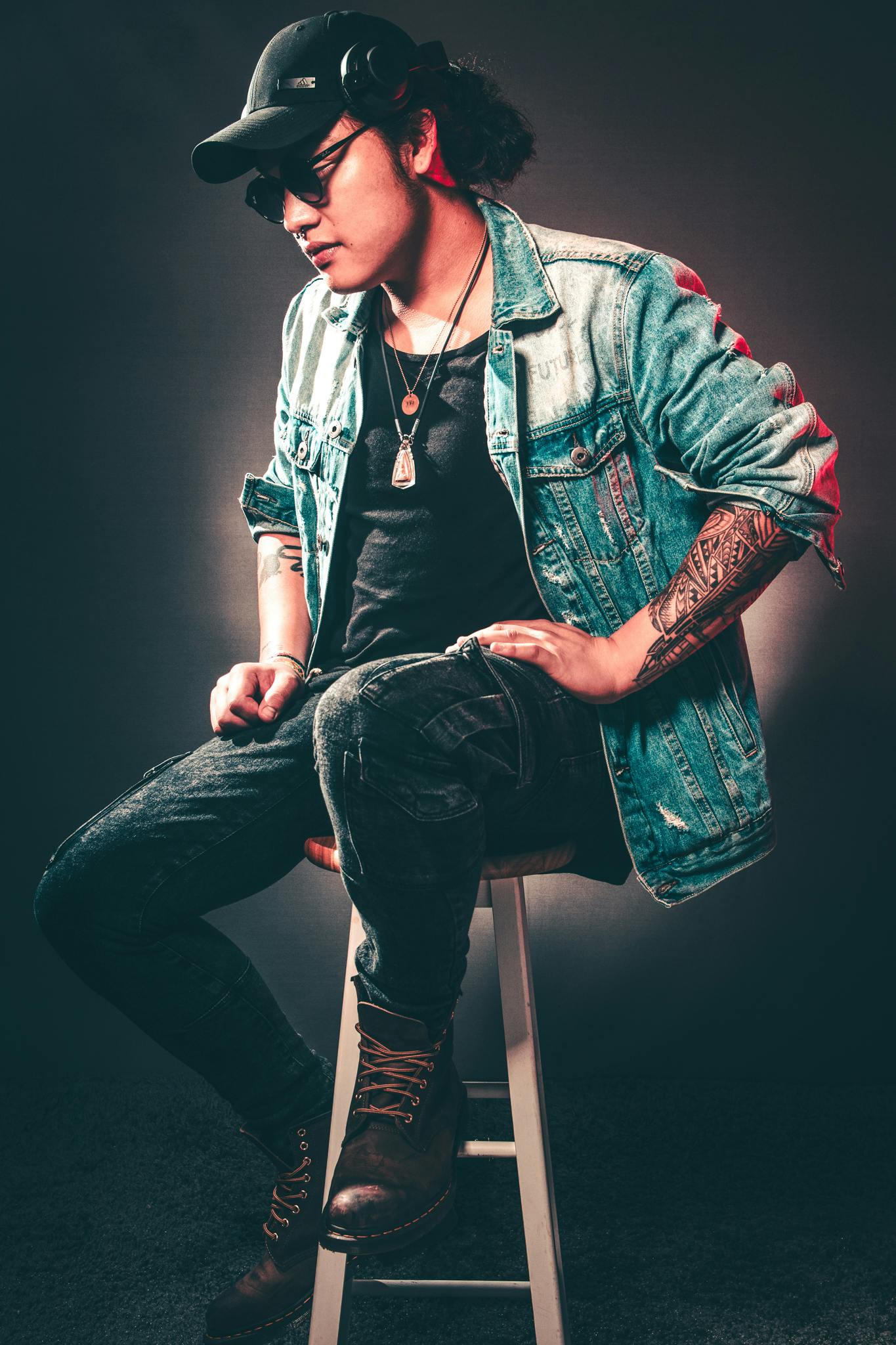 Man Wearing Denim Jacket While Sitting on Chair · Free Stock Photo