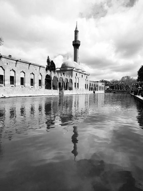 Free Black and white view of the historic Balıklıgöl Mosque reflecting in the calm waters in Şanlıurfa, Turkey. Stock Photo