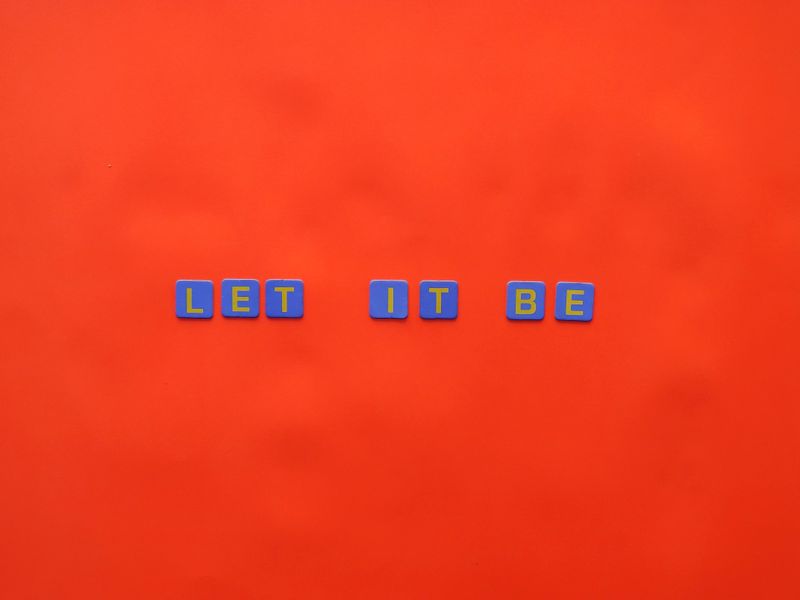 Blue and yellow letter tiles arranged across a red field