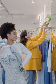 Two women shopping and trying on clothes in a trendy fashion boutique
