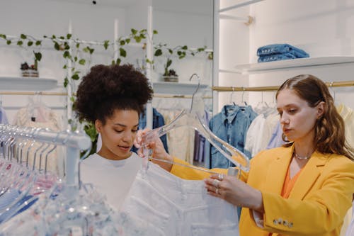 Women Looking at a White Pants Inside a Boutique