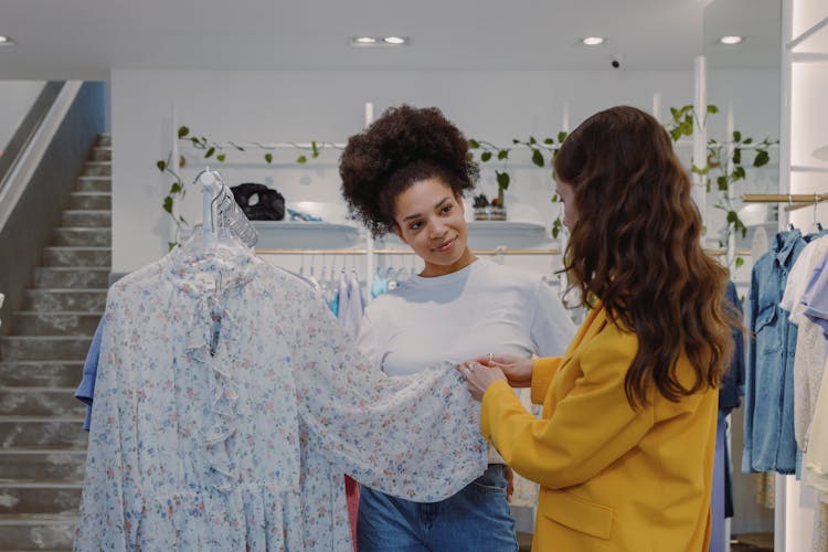 Women Looking At A Floral Dress Inside A Boutique