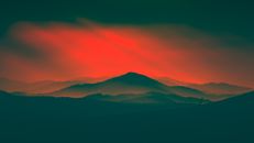 A stunning view of the Podkarpackie mountains at sunset with a dramatic red sky.