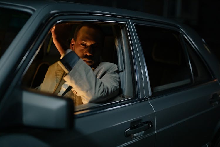 A Man Looking Out Of A Car Window