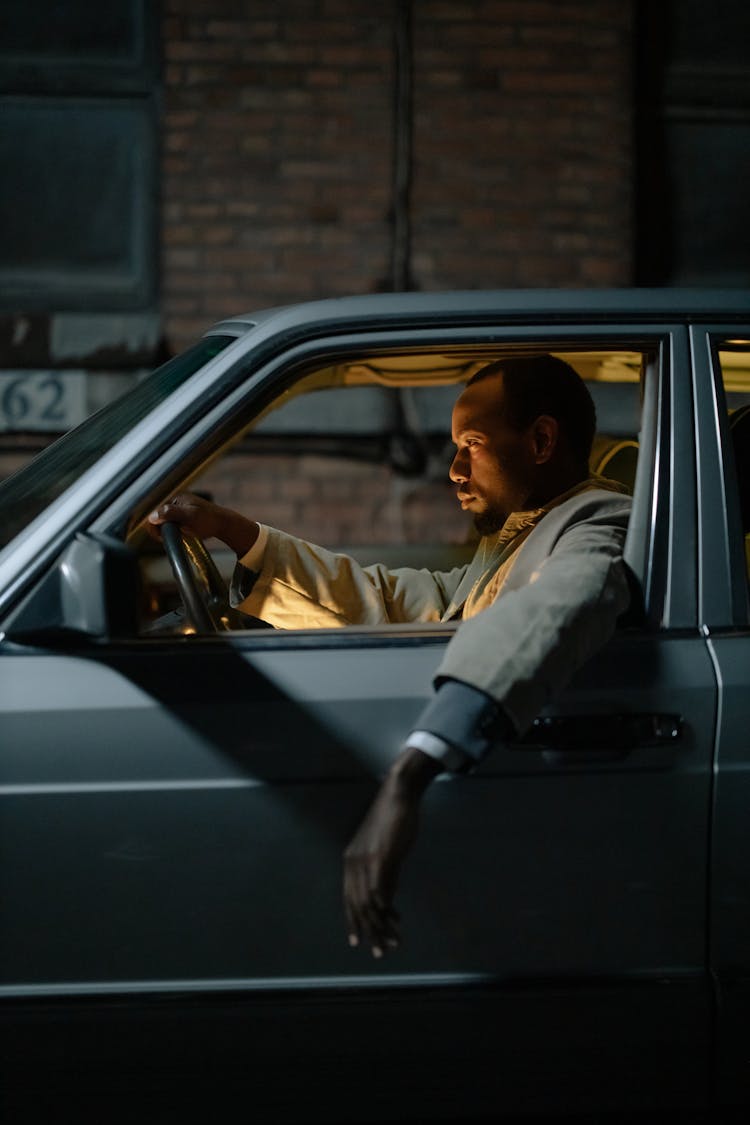 Side View Of A Man Sitting In A Car