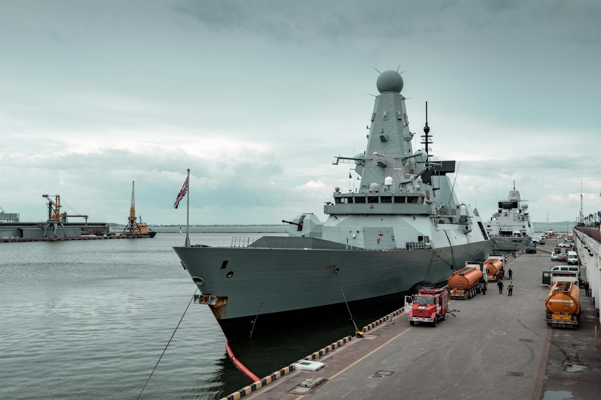 A navy destroyer docked at Odesa harbor with cloudy sky, highlighting maritime defense.