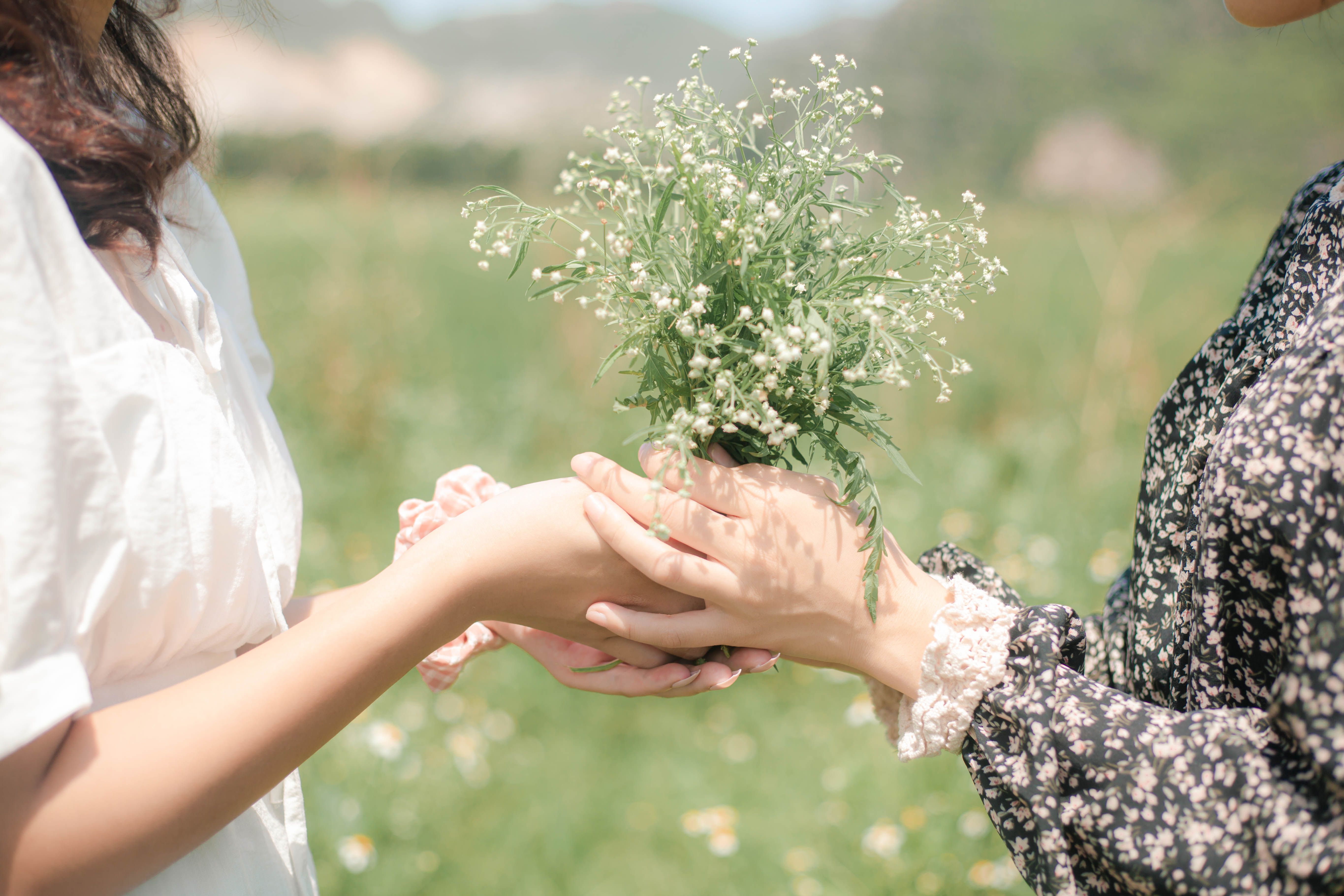 Two friends exchanging a small bouquet of flowers