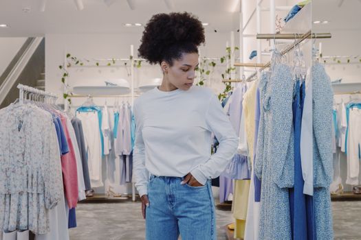 Woman browsing stylish clothes in a modern boutique, dressed casually.