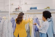 Woman in Yellow Long Sleeve Shirt Standing Beside White and Blue Floral Dress Shirt