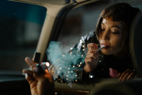 Woman Smoking Cigarette Beside a Car Window
