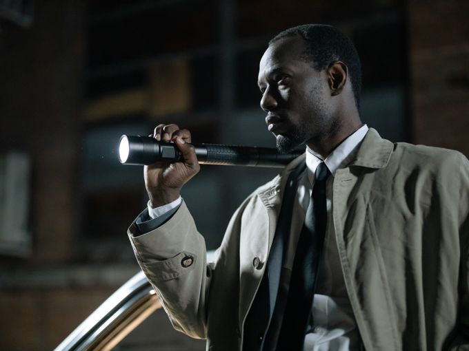 Investigator with a torch examining a scene at night