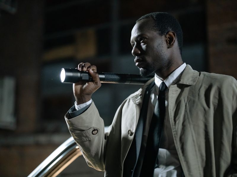 Investigator with a torch examining a scene at night