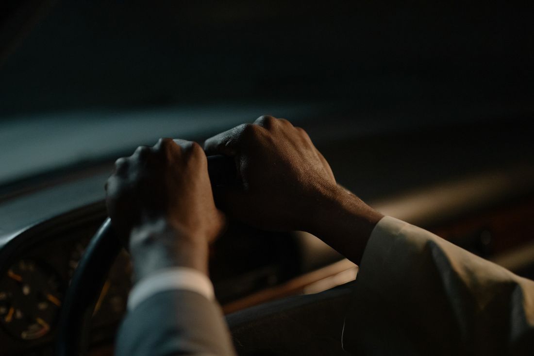 Hands on a steering wheel at night