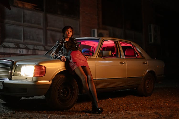 Woman Leaning Against A Car At Night 