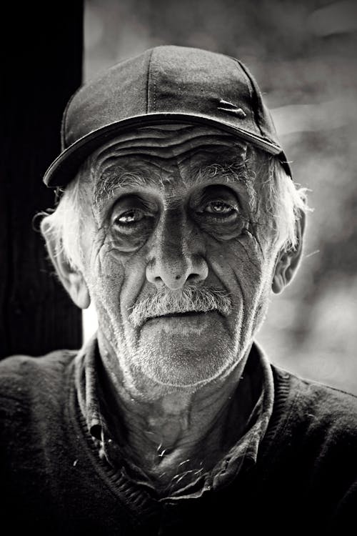 Grayscale Photo of Man Wearing a Hat