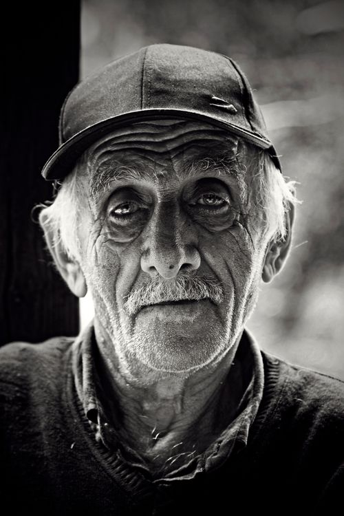 Free Close-up portrait of an elderly man with a hat, highlighting wrinkles and expression. Stock Photo