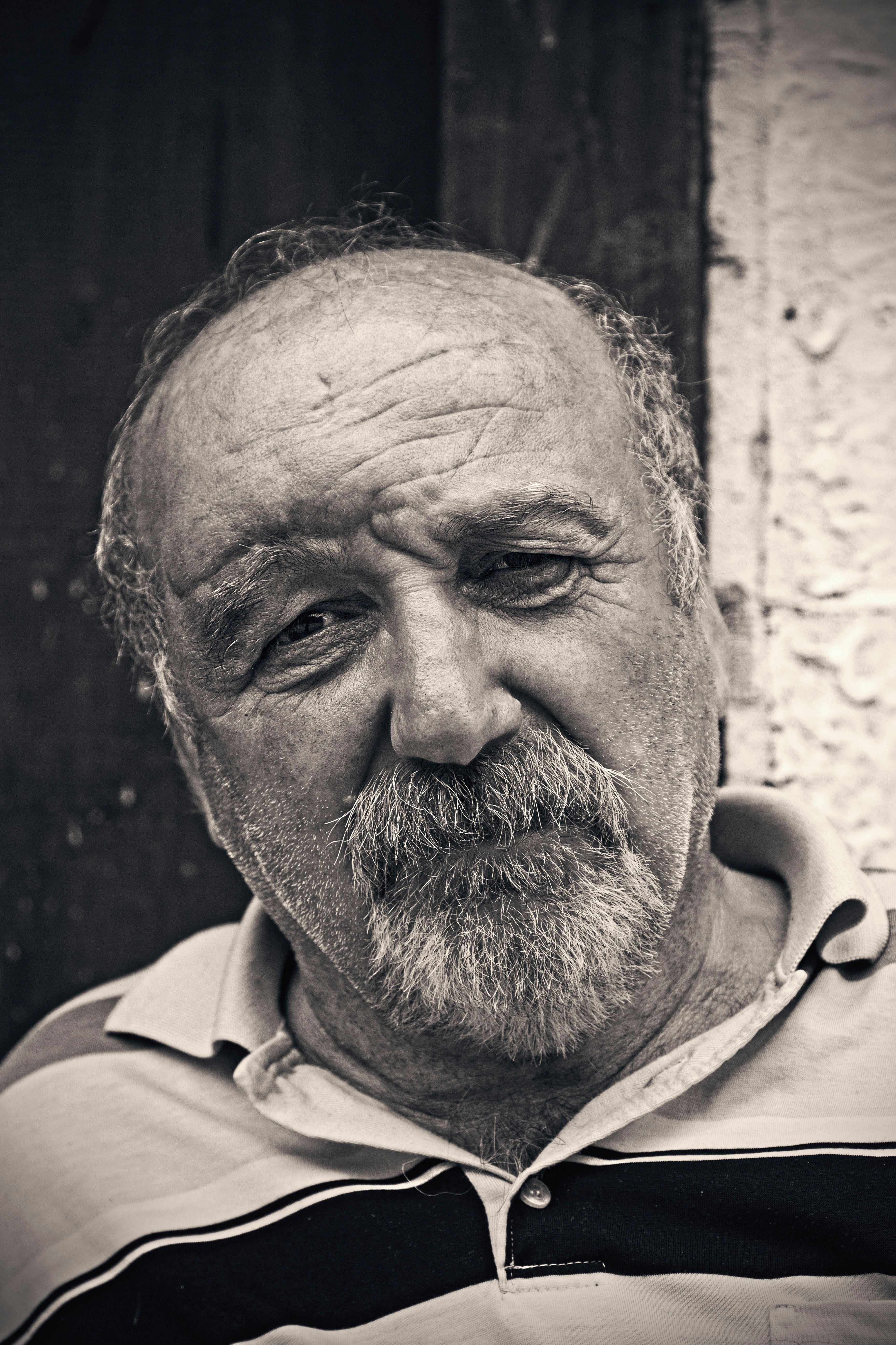 Emotive black and white portrait of a senior man with a beard, showcasing depth and character.
