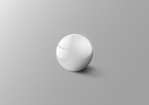 淡灰色背景上，优雅的白色球体反射出柔和光线，营造出极简主义的美感