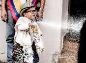 在哥伦比亚纳里诺的一个节日上，一个快乐的孩子用泡沫喷雾庆祝