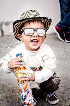 在哥伦比亚，快乐的孩子戴着太阳镜和帽子玩泡沫喷雾
