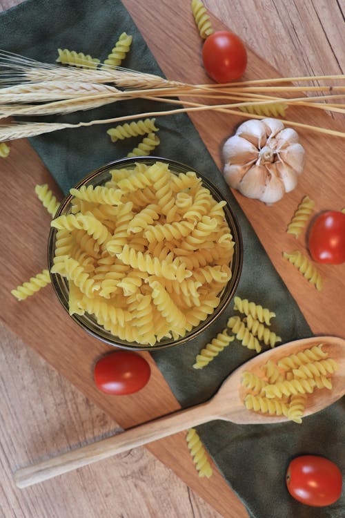 A Plate of Pasta Surrounded with Tomatoes and Garlic