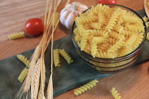 Close-Up Photo of a Pasta Surrounded  with Tomatoes and Garlic