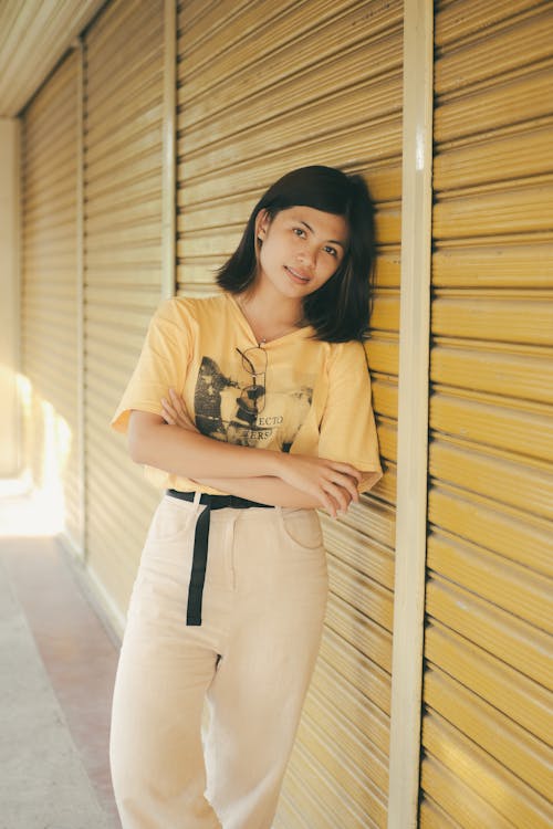 A Young Woman Leaning on a Roller Shutter