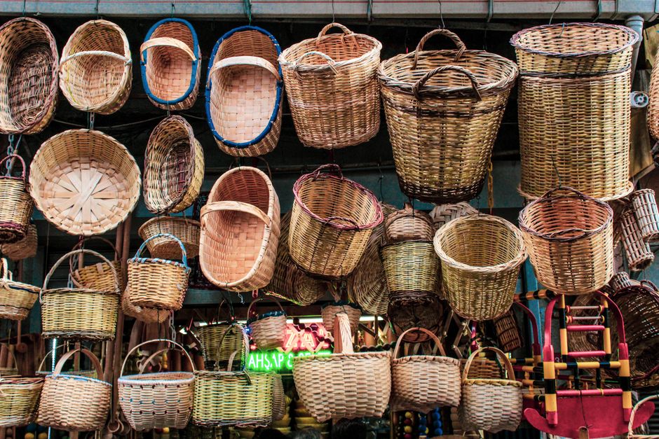 custom made bbq tools - Colorful assortment of handcrafted baskets hanging in a traditional market shop.