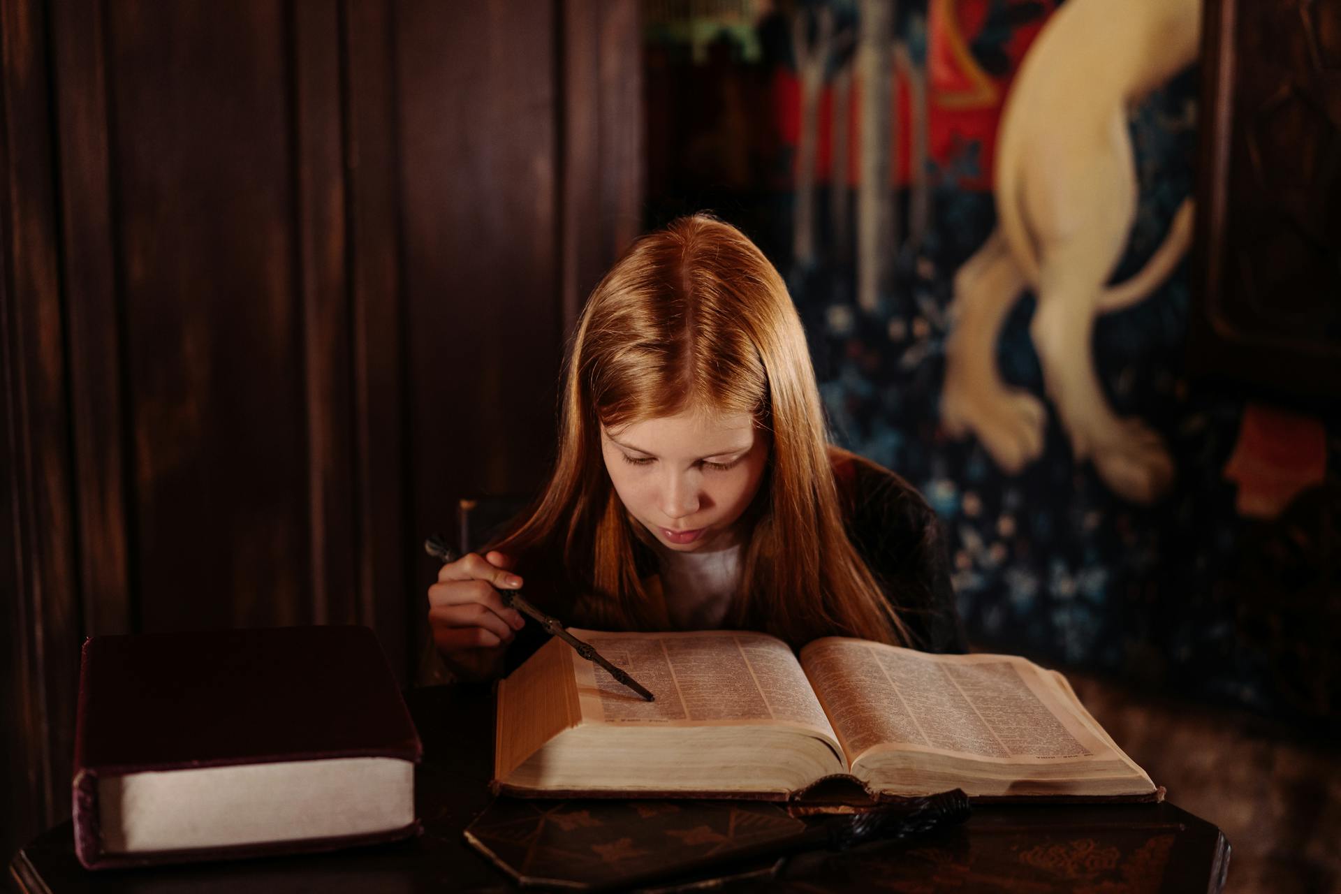 Girl pointing a Wooden Stick on a Book while reading