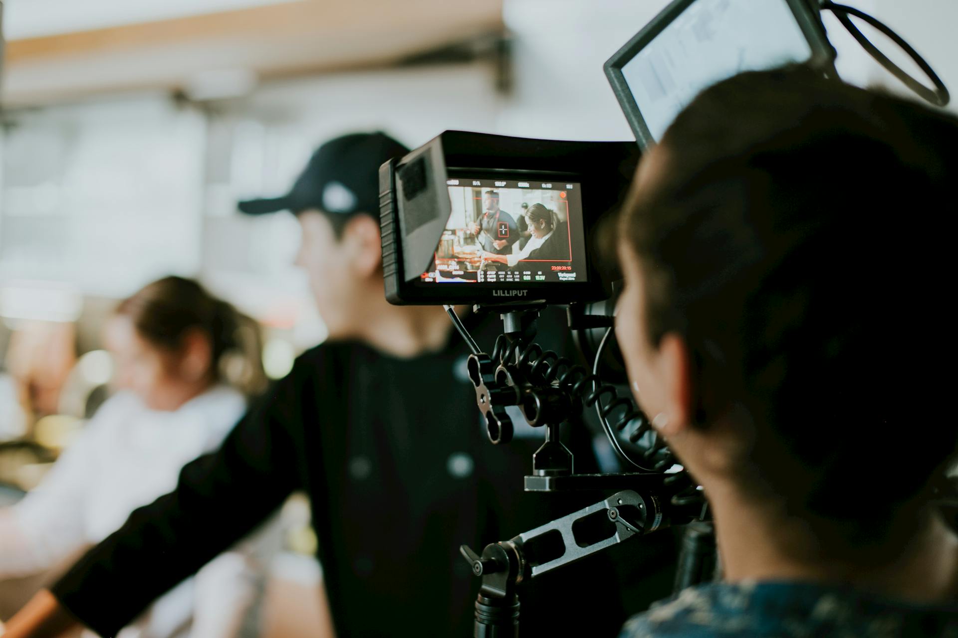 A behind-the-scenes look at a film crew capturing a scene with a focus on a monitor display.