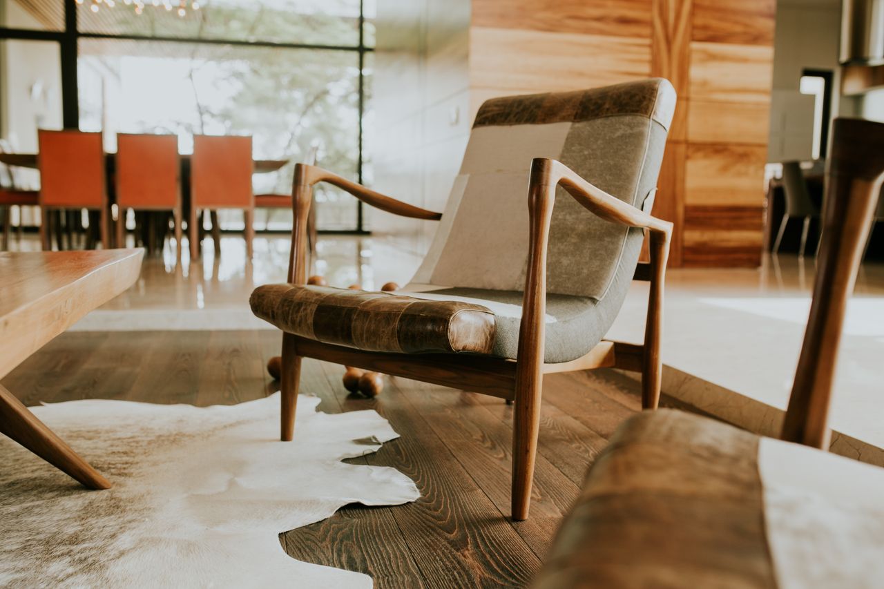Leather lounge chair on a natural cowhide rug over dark wood floors