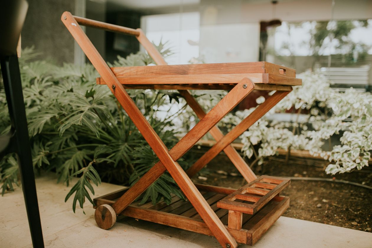 how to style a serving cart: a wooden serving cart amid greenery