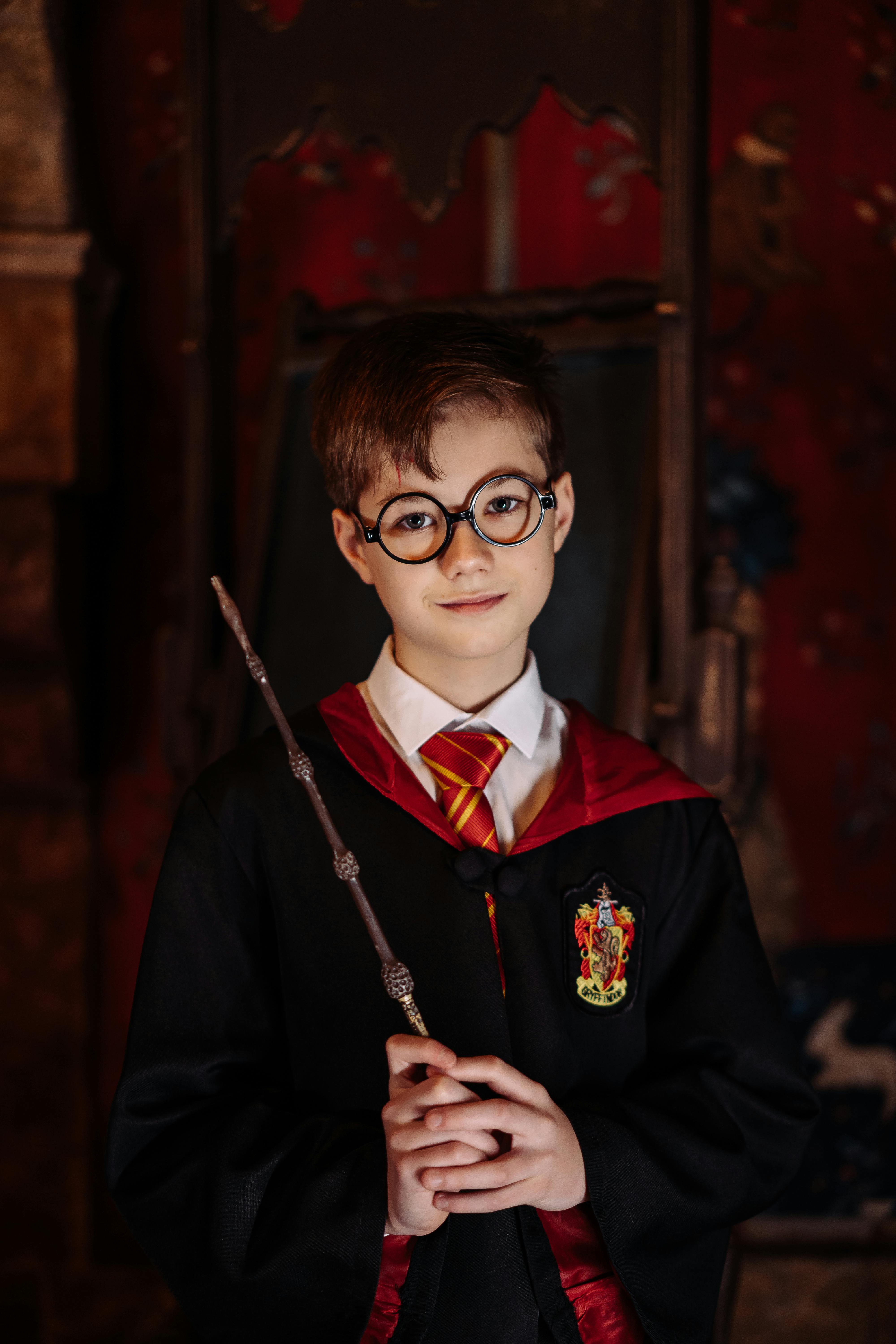 boy in black framed eyeglasses holding a magic wand