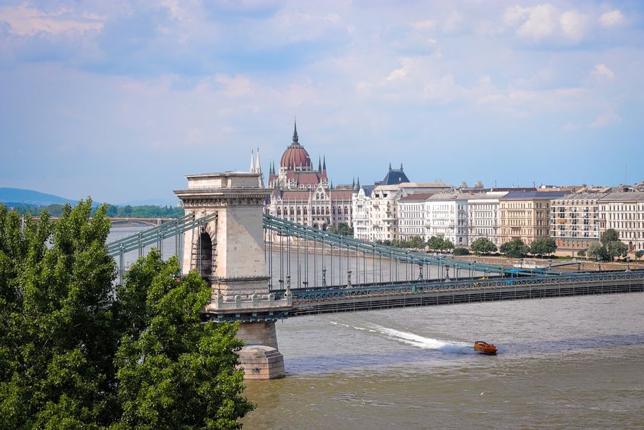 Scenic view of the iconic Széchenyi Chain Bridge over the Danube River with Budapest Parliament in the background.