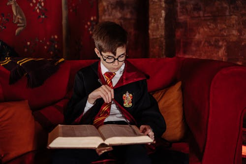 Boy Wearing Harry Potter Costume Reading a Book